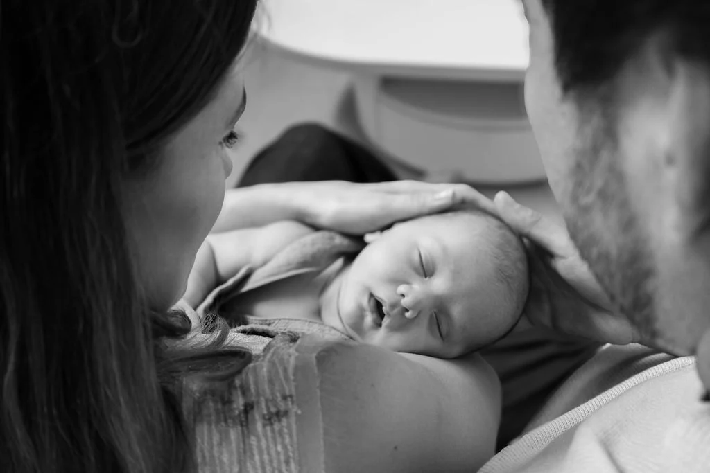 Papás sosteniendo a su recién nacido, fotografía en blanco y negro