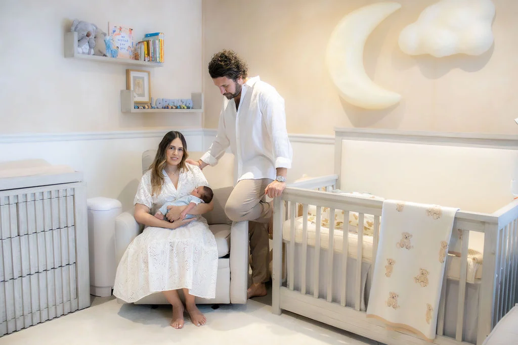 Papás con su recién nacido junto a la cuna